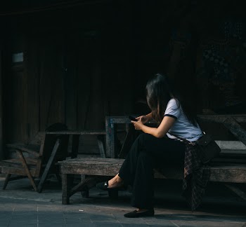 Woman Wearing White Crew-neck Shirt Sitting on Brown Wooden Bench