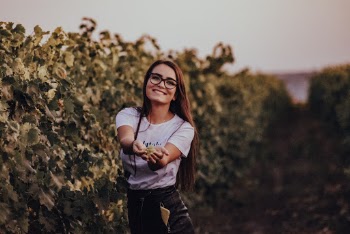 Woman Wearing White Crew-neck T-shirt Standing Beside Green Plants