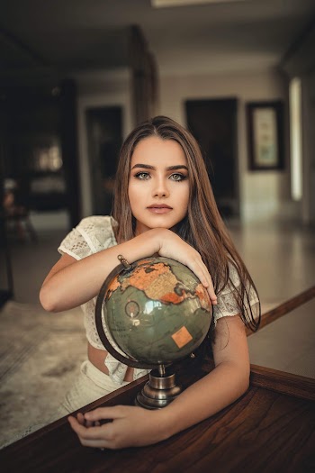 Woman Wearing White Crop Top and White Skirt Holding Political Globe