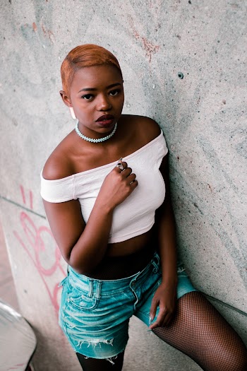 Woman Wearing White Crop Top Leaning on Wall