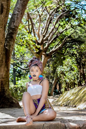 Woman Wearing White Crop Top Sitting on Concrete Floor Near Tree