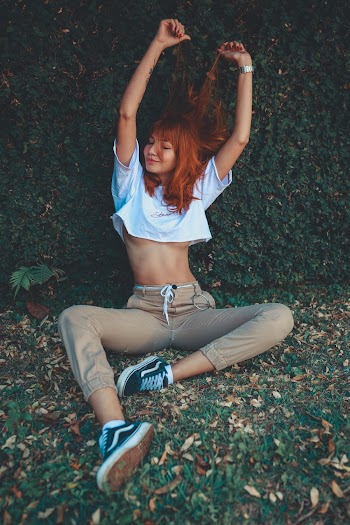 Woman Wearing White Crop Top Sitting On Green Grass