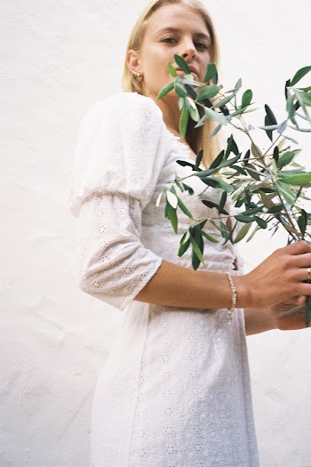 Woman Wearing White Dress Holding Green-leafed Plant