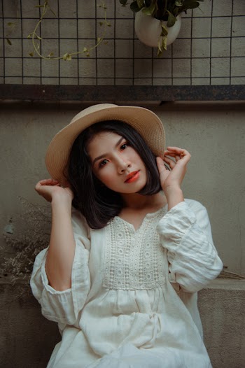 Woman Wearing White Dress Holding Her Sunhat
