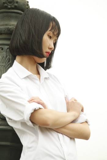 Woman Wearing White Dress Shirt Standing Near Concrete Statue