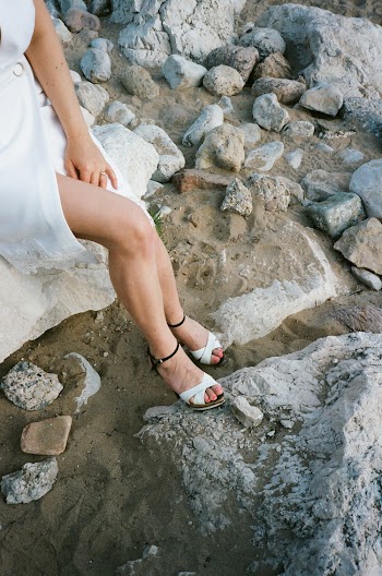 Woman Wearing White Dress Sitting On A Rock