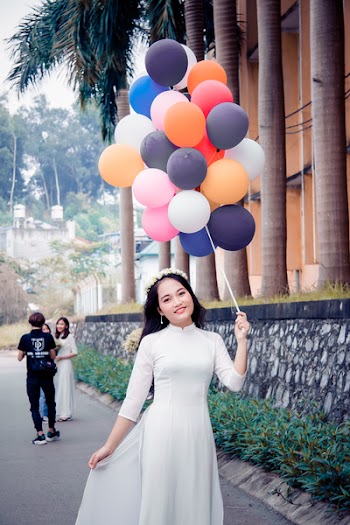 Woman Wearing White Dress While Holding Bundle of Balloons