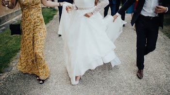 woman wearing white gown between two people