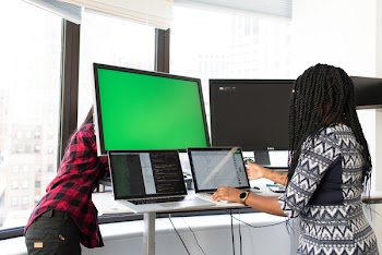 Woman Wearing White, Gray, and Black Elbow-sleeved Dress Using Macbook Pro