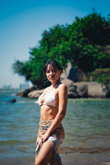 Woman Wearing White Halter Bikini Top And Floral Skirt Standing On Shore