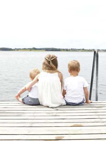 Woman Wearing White Halter Dress Beside Kid Wearing White Crew Neck Shirt Near Body of Water