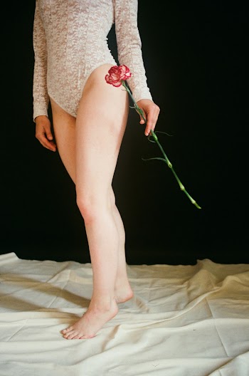 Woman Wearing White Lace  Body Suit Holding Flower