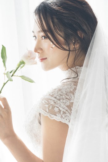 Woman Wearing White Lace Encrusted Wedding Gown and Veil