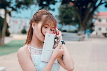 Woman Wearing White Lace Top Holding Book