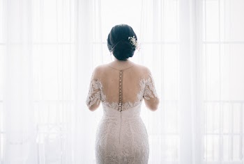 Woman Wearing White Lace Wedding Dress Near White Curtain