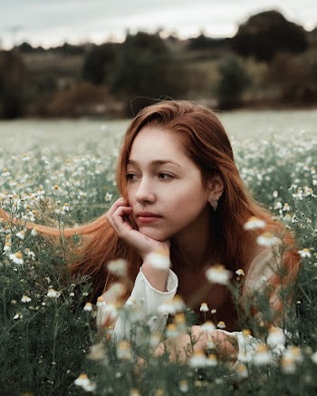 Woman Wearing White Long Sleeve Shirt Laying On White Meadow Flowers