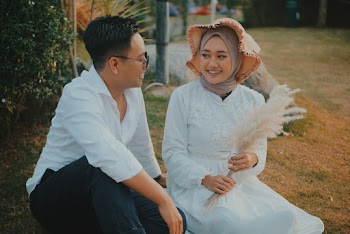 Woman Wearing White Long-sleeved Dress Holding White Flower Sitting Beside of Man Wearing White Dress Shirt and Black Pants