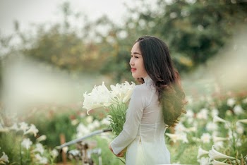 Woman Wearing White Long-sleeved Shirt Holding White Petaled Flowers