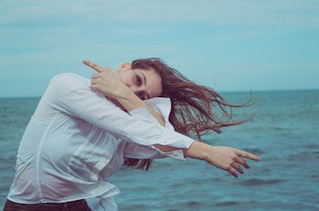 Woman Wearing White Long-sleeved Shirt Posing Near Body of Water