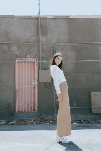 woman wearing white long-sleeved top and brown skirt
