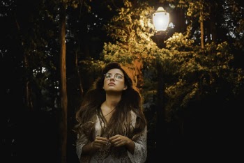 Woman Wearing White Long-sleeved Top Standing Beside Og Black Post Lamp