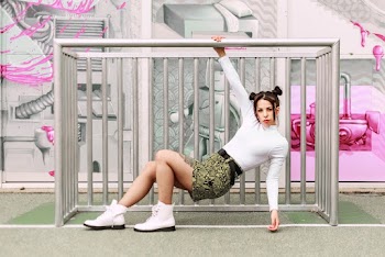 Woman Wearing White Long Sleeves With Black And Yellow Mini Skirt Holding On Metal Railing