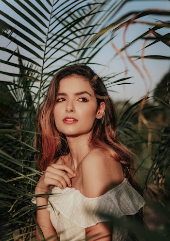 Woman Wearing White Off Shoulder Top Standing Near Green Plants