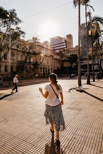 Woman Wearing White Shirt and Gray Skirt While Walking