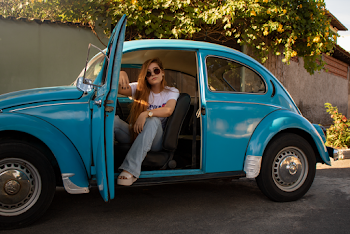 Woman Wearing White Shirt Sitting Inside Blue Volkswagen Beetle