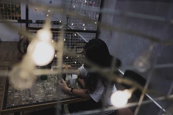 Woman Wearing White Shirt Sitting on Chair Beside Table