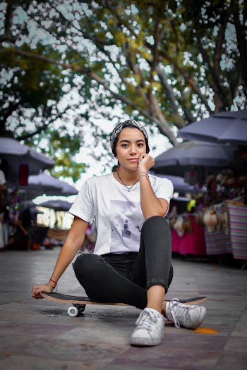 Woman Wearing White Shirt Sitting on Skateboard