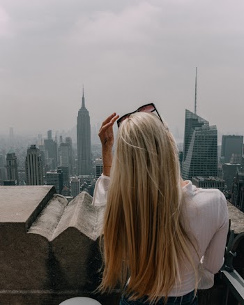 Woman Wearing White Shirt Standing Infront of City Building View