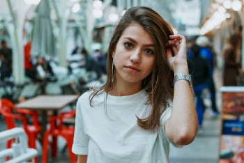 Woman Wearing White Shirt With Table in Background