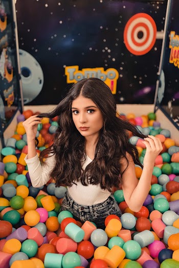 Woman Wearing White Single-sleeved Top on Multicolored Balls