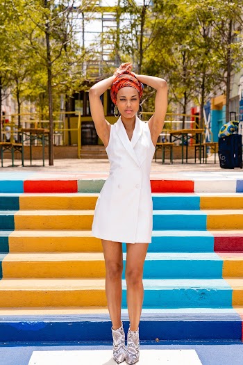 Woman Wearing White Sleeveless Dress Posing Near Multi-colored Stairs