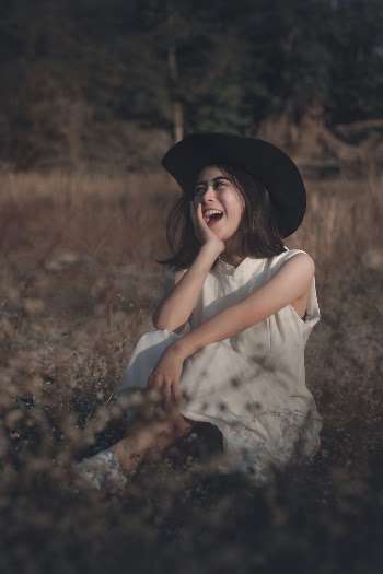 Woman Wearing White Sleeveless Dress Sitting On Grass