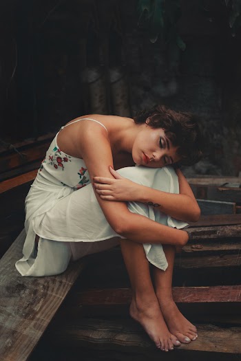 Woman Wearing White Spaghetti Strap Dress Sitting On Brown Wooden Board