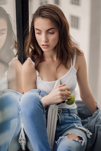 Woman Wearing White Spaghetti Strap Top and Blue Distressed Jeans