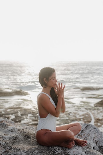 Woman Wearing White Swimsuit Meditating on Mountain