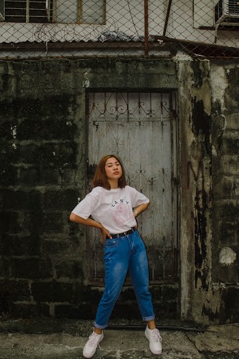 Woman Wearing White T-shirt and Blue Jeans Posing Beside Door