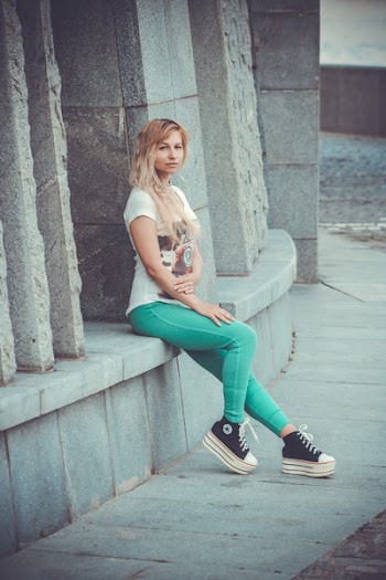 Woman Wearing White T-shirt and Green Pants Posing