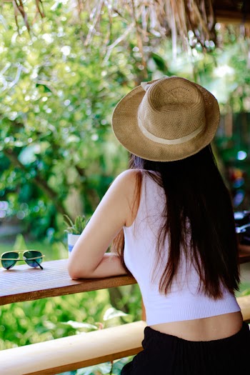Woman Wearing White Tank Top and Black Pants With Brown Sun Hat