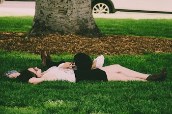Woman Wearing White Tank Top Lying On Green Grass