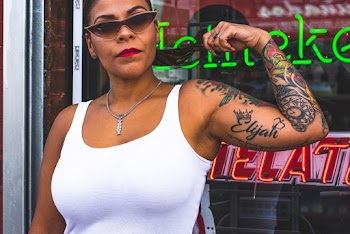 Woman Wearing White Tank Top Showing Arm Tattoos
