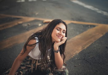 Woman Wearing White Tank Top Sitting on Street