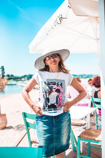 Woman Wearing White Top Across White Outdoor Table Umbrella