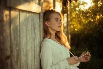 Woman Wearing White Top Leaning on Wooden Wall