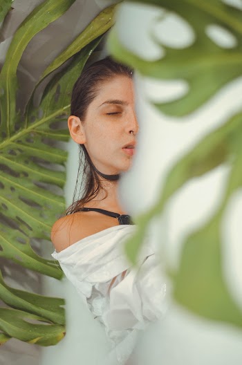 Woman Wearing White Top Standing Near Leaf