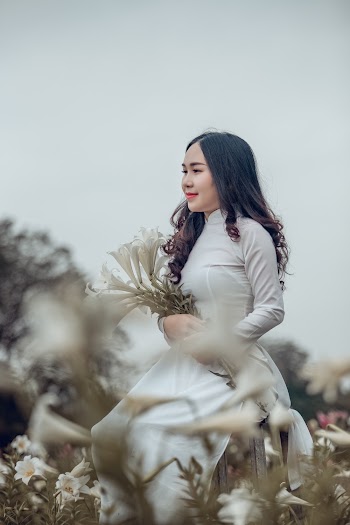 Woman Wearing White Turtleneck Long-sleeved Dress Holding Withe Petaled Flowers