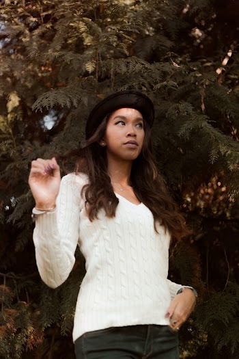 Woman Wearing White V-neck Long-sleeved Shirt and Black Hat Standing Near Green Leaf Plant